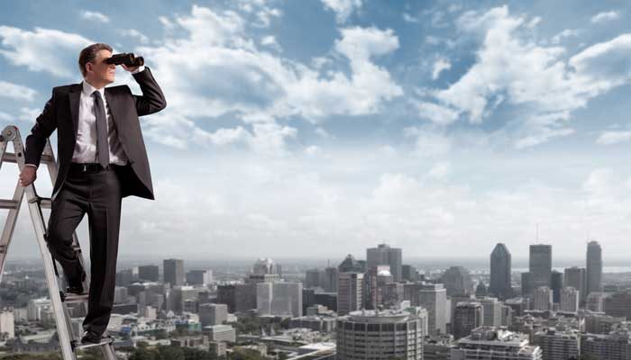 Homen  em uma escada observando com um binobulos, a visão panoramica de uma cidade ao fundo.